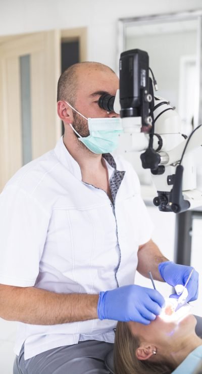 dentist-using-dental-microscope-treating-female-patient-s-teeth