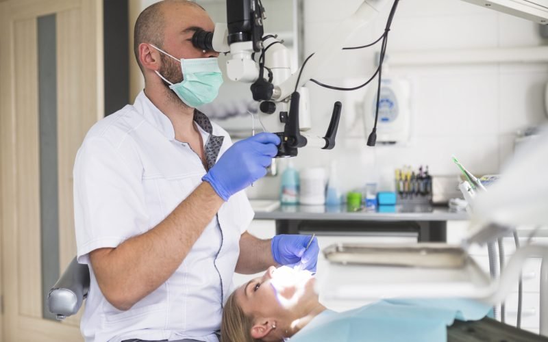 male-dentist-treating-root-canal-female-patient